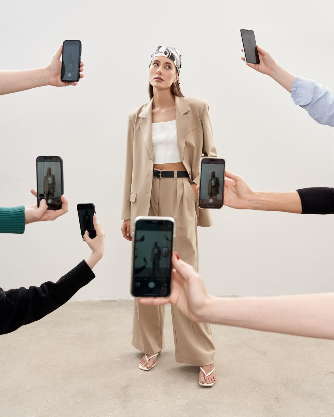 Créatrice de contenu entourée de téléphones pendant une production sociale